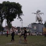 Grassy city square popular for community events with a food court & colonial style water tower.