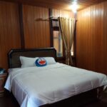 Relaxed wood-built bungalows with porches in a forested resort offering an open-air bar/restaurant.