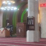 Busy Islamic prayer & study hall with a windowed minaret