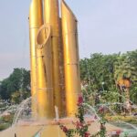 surrounded by fountain & flower beds.