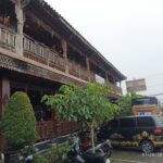 Warung cafes selling rice & noodle dishes in a city square with a memorial to independence heroes.